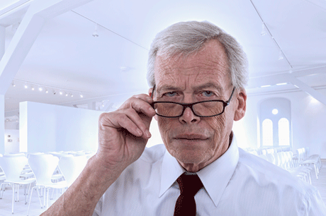 man peering over glasses